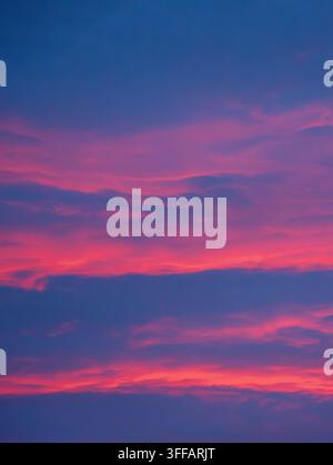 Un tramonto drammatico crea un arazzo surreale di colori e sfumature Foto Stock