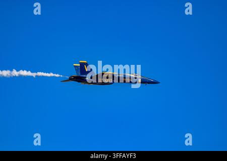 Meridian, MS - 28 marzo 2026: U.S. Navy Blue Angels F/A-18 Super Hornet in volo durante una dimostrazione aerea con una scia di fumo bianca contro un cielo sereno Foto Stock