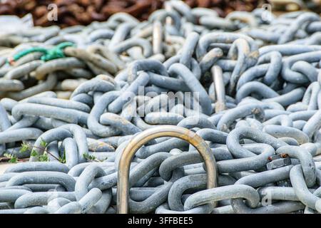 Catene pesanti di metallo intrecciate che riempiono l'inquadratura creando un motivo industriale astratto Foto Stock
