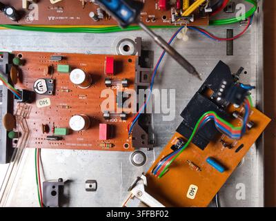 Schede di circuito con componenti elettronici – Vista ravvicinata dall'alto di più schede di circuito interconnesse piene di vari componenti elettronici, Foto Stock