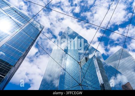 Una vista ad angolazione bassa dei grattacieli moderni in vetro attraverso i cavi sospesi del tram. Foto Stock