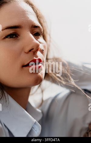 Ritratto di donna all'aperto, primo piano di una donna pensierosa che guarda lontano alla luce del sole con un'atmosfera serena e riflessiva Foto Stock