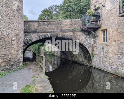 Edificio in pietra e ponte lungo il canale a Skipton Foto Stock