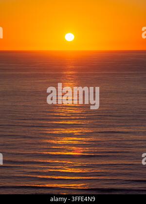 Vista aerea del sole che tramonta sul Pacifico al largo della costa di Bandon, Oregon, Stati Uniti. Foto Stock