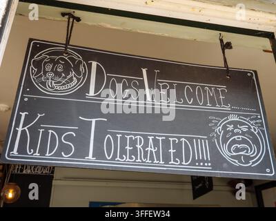 Insegna umoristica in un caffè che dice "cani benvenuti, bambini tollerati", Londra, Regno Unito Foto Stock