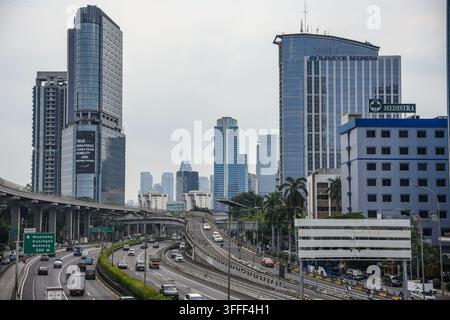 Vista delle strade trafficate e dell'autostrada sopraelevata a Jakarta con grattacieli moderni e edifici per uffici sullo sfondo, Jakarta, Jakarta, Indonesia. Foto Stock