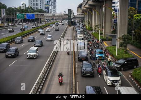 Vista di traffico intenso con auto e motociclette su un'autostrada urbana affollata a Jakarta, Jakarta, Indonesia. Foto Stock