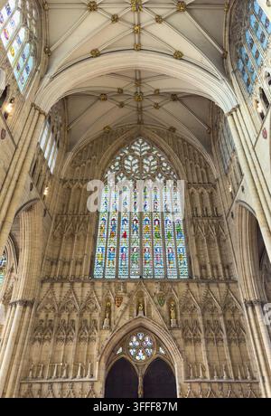 Interno del York Minster con volte in pietra gotiche e un grande vetrata colorata all'interno della cattedrale di York, Inghilterra. Foto Stock