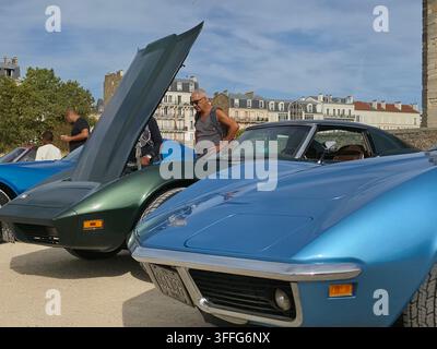 Auto sportive classiche Chevrolet Corvette C3 in mostra a una fiera di auto vintage all'aperto, con un modello blu in primo piano e un modello verde scuro Foto Stock