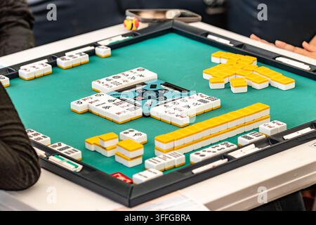 Persone che giocano a Mahjong per strada, un gioco a piastrelle per tre o quattro giocatori Foto Stock