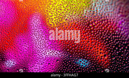 Fotografia macro di goccioline d'acqua cromatiche  Una fotografia macro che mostra una densa disposizione di goccioline d'acqua iridescenti raggruppate su una superficie di vetro, cre Foto Stock