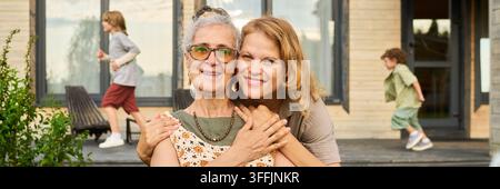 Ritratto di una madre anziana e di sua figlia che sorridono all'aperto Foto Stock