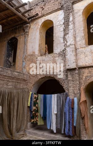 Vista di biancheria appesa a una corda contro i muri di mattoni erosi e le porte ad arco dell'antica cittadella di Erbil, Governatorato di Erbil, Iraq. Foto Stock