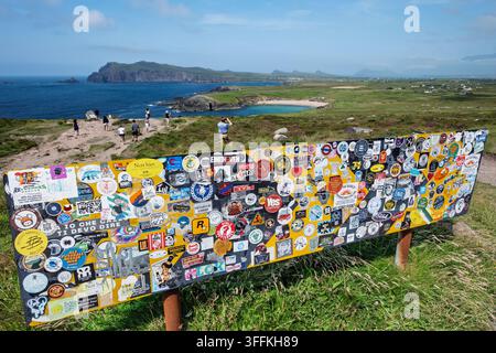 Un cartello stradale coperto di adesivi, punto panoramico Ceann Sibéal, Slea Head Drive, Wild Atlantic Way, penisola di Dingle, contea di Kerry, Irlanda Foto Stock