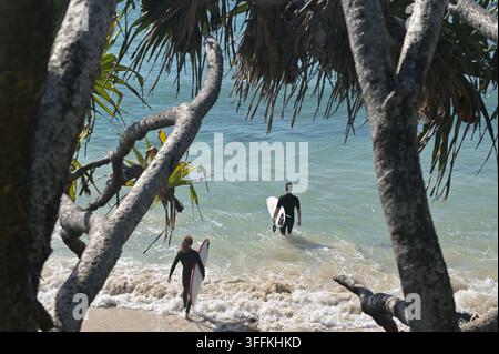 GOLD COAST - 28 GIUGNO 2024: Veduta aerea di una coppia di surfisti australiani che surfano su un'onda a Surfers Paradise, Gold Coast, Queensland, Australia. Foto Stock