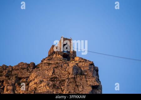 Vista della stazione della funivia della Montagna della Tavola appollaiata sulla cima rocciosa della Montagna della Tavola durante l'ora dorata a Città del Capo, Capo Occidentale, Sudafrica Foto Stock