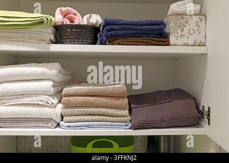 Organizzazione estetica dello spazio domestico con asciugamani da bagno ordinatamente piegati. Foto Stock