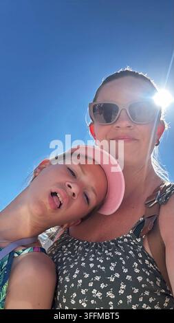 Madre e figlia felici che scattano un selfie sciocco durante una vacanza estiva soleggiata. Foto Stock