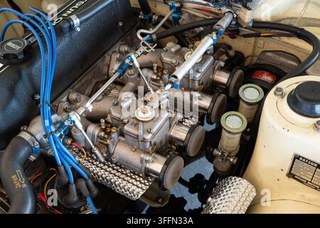 Kemptthal, Zurigo, Svizzera, 6 settembre 2026. Vista ravvicinata ad angolo elevato del vano motore di un Datsun vintage con doppi carburatori, pile di velocità e Foto Stock