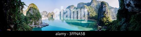 Vista panoramica sull'acqua turchese e sulle imponenti isole carsiche di calcare nella baia di Ha Long, Vietnam. Foto Stock