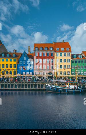Case storiche colorate e barche lungo il lungofiume Nyhavn a Copenaghen, Danimarca, in una luminosa giornata estiva Foto Stock