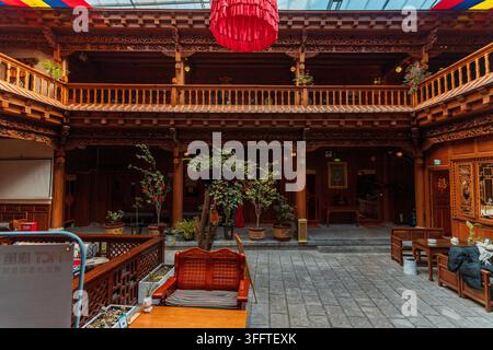 Balcone intagliato nel legno e vista sul cortile interno di una guesthouse tibetana Foto Stock