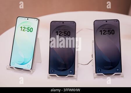 RIGA, LETTONIA. 25 agosto 2026. Trio di smartphone Samsung Galaxy S26 FE posizionati su supporti, che visualizzano schermi di blocco sincronizzati con l'ora impostata su Foto Stock