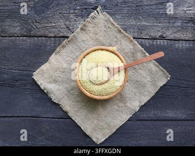 Couscous crudo in una ciotola di legno Foto Stock