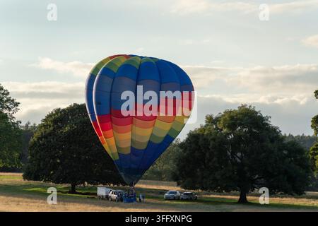 Bakewell, Regno Unito - 05 settembre 2026: Vista dei terreni di Chatsworth House con un pallone aerostatico colorato che si prepara per il volo, circondato da lus Foto Stock
