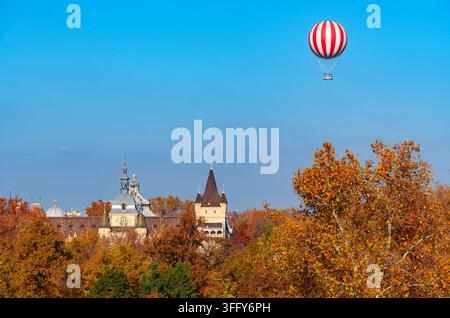 Un pallone aerostatico come piattaforma panoramica per turisti vola alto nel cielo sopra le cime degli alberi e il castello di Vajdahunyad a Budapest, Ungheria Foto Stock