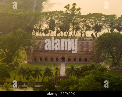 Vista aerea della storica moschea Sixty Dome con i suoi distintivi cupoli in terracotta circondati da una vegetazione lussureggiante e da uno stagno a Bagerhat, divisione di Khulna Foto Stock