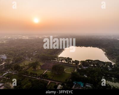 Vista aerea della storica moschea dei Sessanta Cupole circondata da una vegetazione lussureggiante e dallo stagno Ghoradighi al tramonto a Bagerhat, divisione di Khulna, Bangladesh. Foto Stock