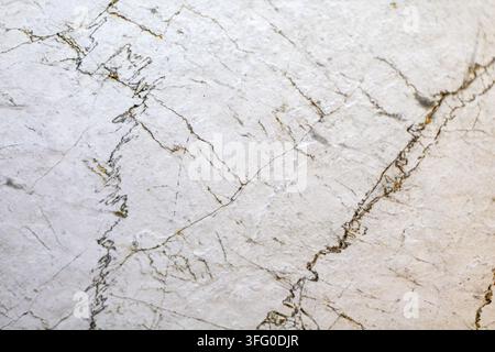 Texture di marmo bianco con sottili venature scure naturali. Close-up di pietra di marmo bianco con sottili venature scure, crepe e una texture naturale sottile. Foto Stock