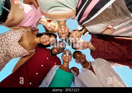 Gruppo di amici diversificati e felici in piedi in cerchio, sorridenti, creando un senso di unità e comunità Foto Stock