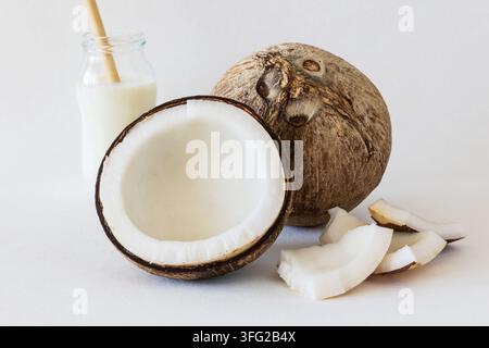 Noce di cocco e yogurt al cocco, intere e tagliate a metà, con polpa fresca Foto Stock