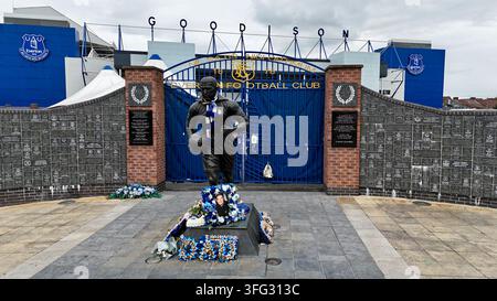 Statua di Dixie Dean e muro commemorativo dell'Everton FC fuori dallo stadio di calcio Goodison Park a Liverpool, Inghilterra, con omaggi floreali alla base Foto Stock