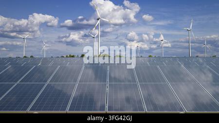Pannelli solari sullo sfondo di turbine eoliche Foto Stock