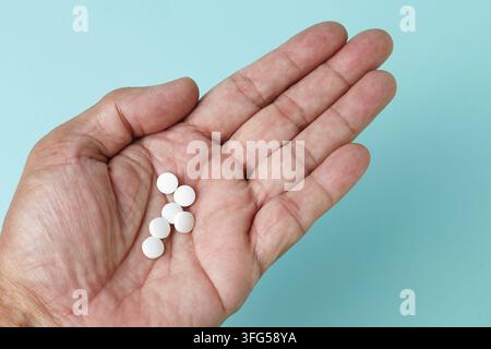 Diversi compresse bianche nel palmo della mano Foto Stock