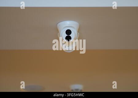 Telecamera di sicurezza montata sul soffitto in uno spazio interno Foto Stock