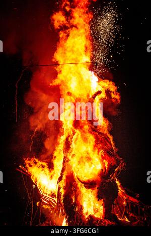 EFFIGIE IN COLLASO IN UN BAGLIORE DI GLORIA, EFFIGIE DI UOMO DI VIMINI IN FIAMME, FESTIVAL GREEN MAN, BRECON, GALLES, REGNO UNITO, 2018: La struttura di una grande effigie cornuta in fiamme inizia a crollare nel cuore dell'inferno mentre volano scintille. Foto: Rob Watkins. INFO: Il festival Green Man si tiene ogni anno nelle Brecon Beacons ad agosto. Celebra musica, arte, letteratura, scienza e cultura adatte alle famiglie in uno splendido scenario montano. Ogni anno il festival si conclude con il rituale di bruciare l'effigie dell'Uomo di vimini Green Man. Foto Stock