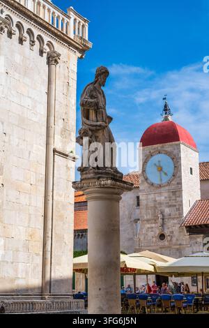 Statua di San Lorenzo accanto alla Cattedrale di San Lorenzo, con torre dell'orologio sullo sfondo, nella vecchia città di Trogir sulla costa dalmata della Croazia Foto Stock