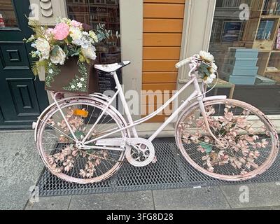 Vecchia bicicletta con decorazione floreale davanti a una porta d'ingresso in stile nostalgico, Trondheim, Trøndelag, Norvegia Foto Stock