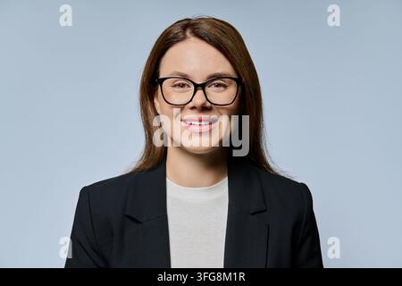 Donna d'affari con occhiali che guarda verso la telecamera, primo piano, ritratto in studio Foto Stock
