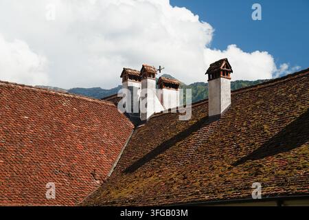 Camini storici sul tetto in tegole di argilla dell'Abbazia di Interlaken in Svizzera Foto Stock
