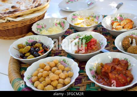 Mezze mediorientali servite in piccoli piatti bianchi su un vassoio di bambù intrecciato a Dubai Foto Stock
