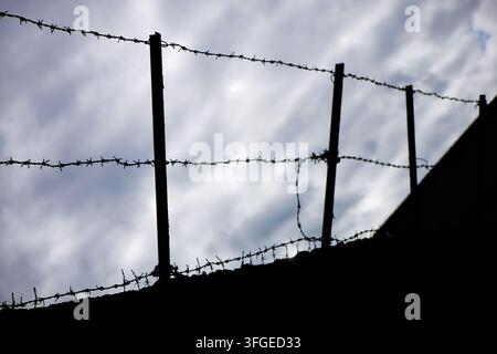 Una sagoma di filo spinato contro un cielo nuvoloso - Wolverhampton, Regno Unito Foto Stock