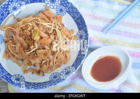 Pad Thai spaghetti di riso saltati con uovo e germogli di fagiolo coppia di erba cipollina su piatto salsa di peperoncino Foto Stock