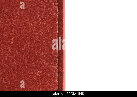 Primo piano di una cucitura verticale su un bordo in pelle marrone rosso con spazio per il testo su sfondo bianco Foto Stock
