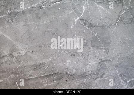 Texture di pietra di marmo grigio con venature bianche. Primo piano di pietra di marmo grigio con sottili venature bianche, crepe e texture naturale. Foto Stock