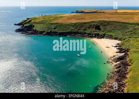Vista aerea ad angolo alto di Watwick Bay nel Pembrokeshire, piccole barche ancorate al largo di una spiaggia sabbiosa circondata da scogliere costiere e campi verdi, Galles occidentale Foto Stock